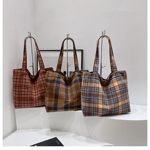 Detailed close-up of three plaid wool tote bags in red, green, and blue-beige tones