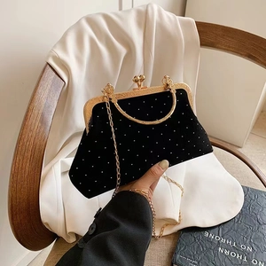 Detail of vintage black velvet evening bag with white polka dots and gold ring handle