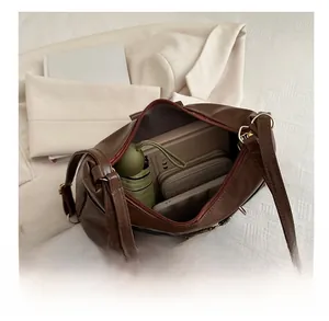 Interior view showing the large capacity of the dark brown leather tote bag with accessories