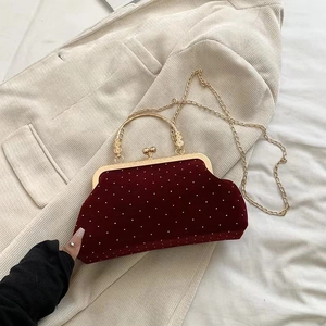 Detail of red velvet evening bag with white polka dots and vintage gold metal clasp