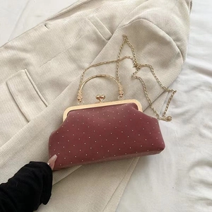Detailed view of burgundy vintage doctor bag with gold rivets and pearl clasp