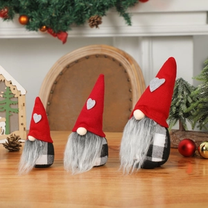 Trois gnomes de Noël avec chapeaux rouges tricotés et motifs à carreaux noir et blanc