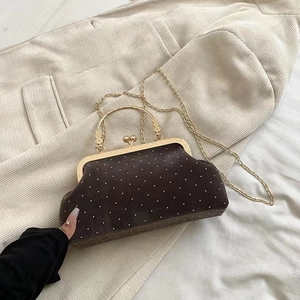 Detail of vintage brown suede evening bag with pearl accents and golden kiss-lock handle
