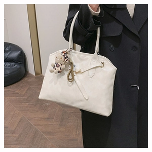 Detail der weißen Leder-Shopper-Tasche mit einem süßen Plüsch-Kätzchen am Griff
