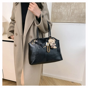 Elegante schwarze Muschel-Tragetasche aus Leder mit Hello Kitty Anhänger und Tragegriffen