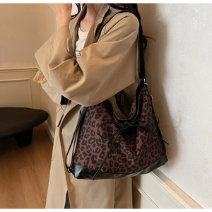 Detail of leopard print tote bag with black leather piping and leather bow decoration