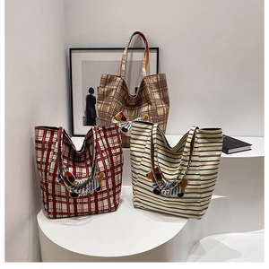 Close-up of canvas tote bags with Dachshund embroidery in various plaid patterns