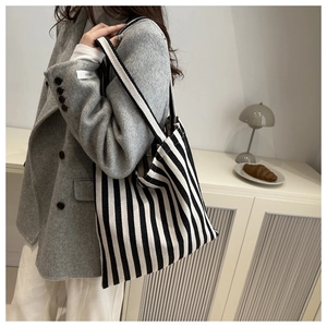 Chic black and white striped canvas tote bag shown as a shoulder bag for daily commuting