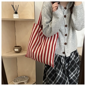 Close-up of red and white striped canvas tote bag with wide shoulder strap