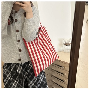 Mirror selfie showing a red and white striped canvas tote bag in a casual lifestyle setting