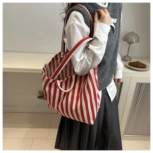 Vue détaillée du sac en toile rayé avec des motifs verticaux rouges et blancs