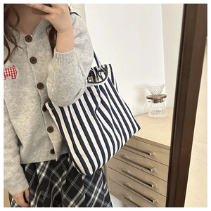 Sac fourre-tout en toile à rayures bleues et blanches avec une tenue décontractée