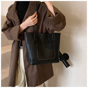 Detail der schwarzen Leder-Tote-Bag mit geprägtem Karomuster und Kontrastnähten in Weiß