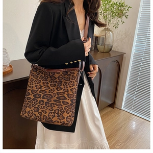 Dettaglio della borsa shopper leopardata con cinturini marroni e fibbia in metallo