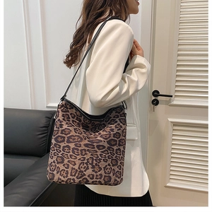 Dettaglio della borsa a spalla leopardata abbinata a blazer bianco e gonna a pieghe