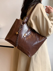 Grand sac cabas marron foncé aspect brillant avec pendentif décoratif à clochette