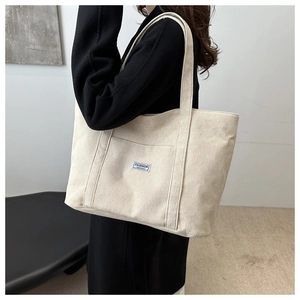 Detail of off-white corduroy tote bag showing spacious design and fashion front pocket
