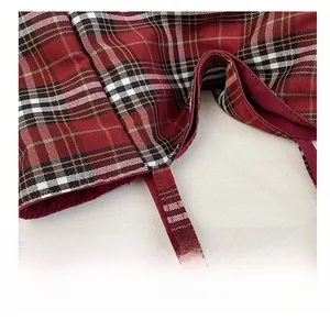 Macro detail of high-density stitching and classic red plaid fabric on this tote bag