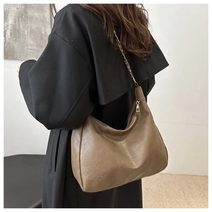 Détail du sac cabas marron avec bandoulière élégante en chaîne métallique et cuir