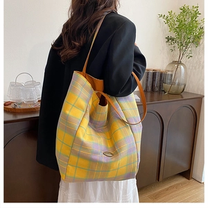 Macro detail of checkered yellow and purple tote bag with orange leather straps