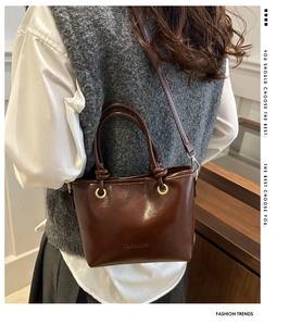 Close-up of vintage brown leather tote bag showing handle detail and fashion embossing