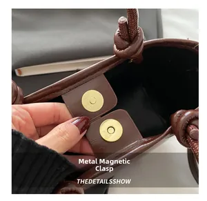 Close-up of the magnetic closure on a brown PU leather vintage crossbody bucket bag