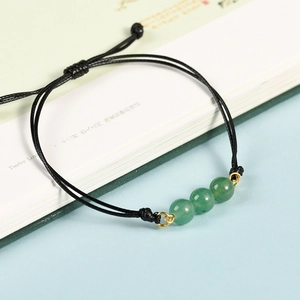 Bracciale fatto a mano in cordino nero con tre perline verdi e dettagli dorati