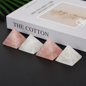 Polished rose and clear quartz crystal pyramids on a minimalist black surface