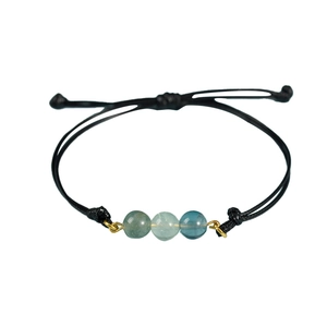 Bracciale artigianale in cordino nero con tre perle di pietra naturale e dettagli dorati