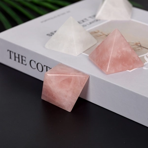 Polished natural rose quartz and clear crystal pyramids on a minimalist desk