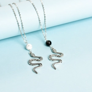 Retro snake pendant necklaces set with crystal beads on light blue elegant display stand