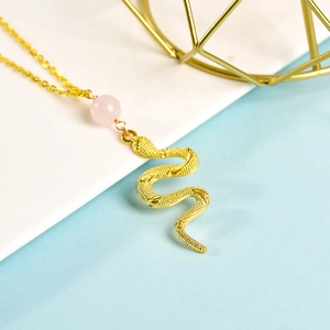 Elegant gold snake pendant necklace with pink crystal bead on minimalist metal chain