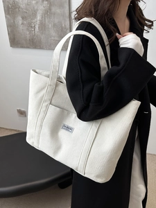 Large off-white corduroy tote bag with front pocket and fashion label for casual commuting