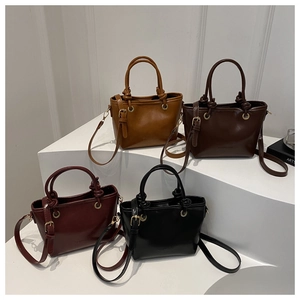 Retro trapezoid leather handbags in four colors displayed on a white tiered stand