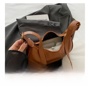 Detailed interior of the brown lychee leather dumpling bag showing large storage capacity