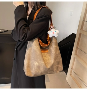 Grand sac fourre-tout vintage texture marbre avec pendentif étoile porté sur un tailleur noir
