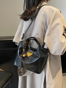 Sac fourre-tout élégant en similicuir noir avec logo doré et détail de charme tressé