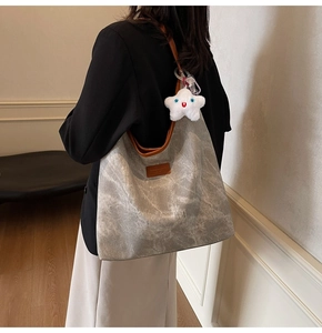 Détail du sac cabas en toile marbrée grise avec lanières cuir et breloque étoile