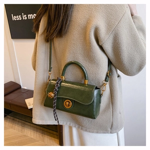 Dunkelgrüne Retro-Handtasche mit goldenem Verschluss und dekorativem Web-Anhänger