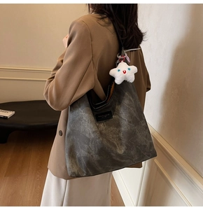 Détail du sac cabas gris à motif marbré avec pendentif étoile et bandoulière en cuir