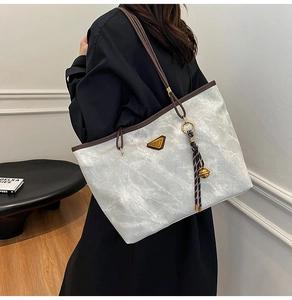 Détail du grand sac cabas gris marbré avec anses marron et pendentif à pompon