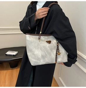 Vue de côté du grand sac cabas en toile marbrée grise avec finitions en cuir marron
