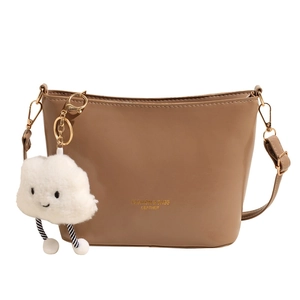 Brown leather crossbody bucket bag featuring a cute white plush cloud charm and strap