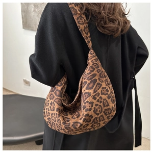 Detail view of stylish leopard print crescent bag with wide integrated shoulder strap