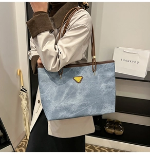 Détail du sac cabas bleu clair avec texture flocon de neige et poignées en cuir marron