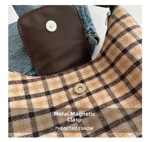 Détail du fermoir magnétique en métal sur un sac fourre-tout en toile à carreaux