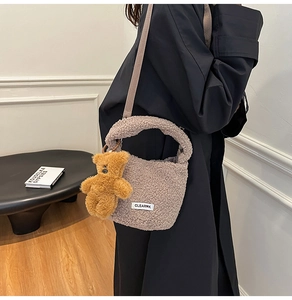 Detail of plush bucket bag with lamb wool texture, bear pendant and adjustable strap