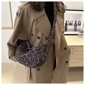 Detailed leopard print tote bag with half-moon shape worn over a khaki trench coat