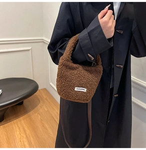 Gros plan du sac à main en peluche marron avec étiquette blanche et bandoulière