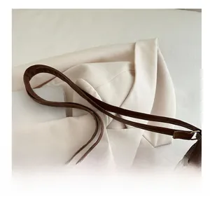 Detail view of the brown leather tote handle stitching and top zipper closure design